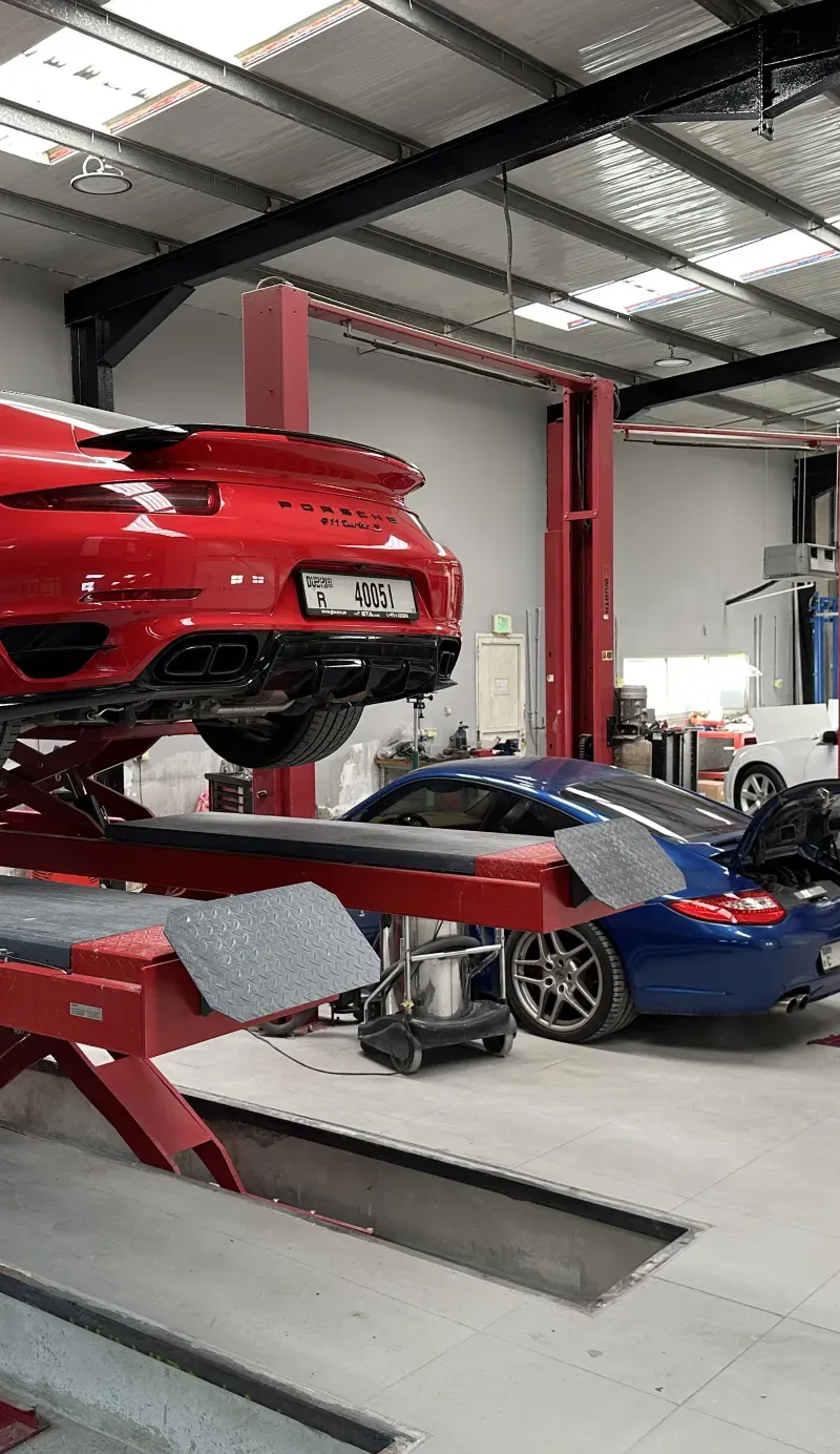 Red Porsche raised on a workshop lift